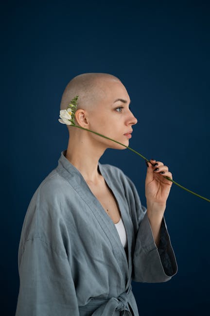 Woman with shaved head holding a flower